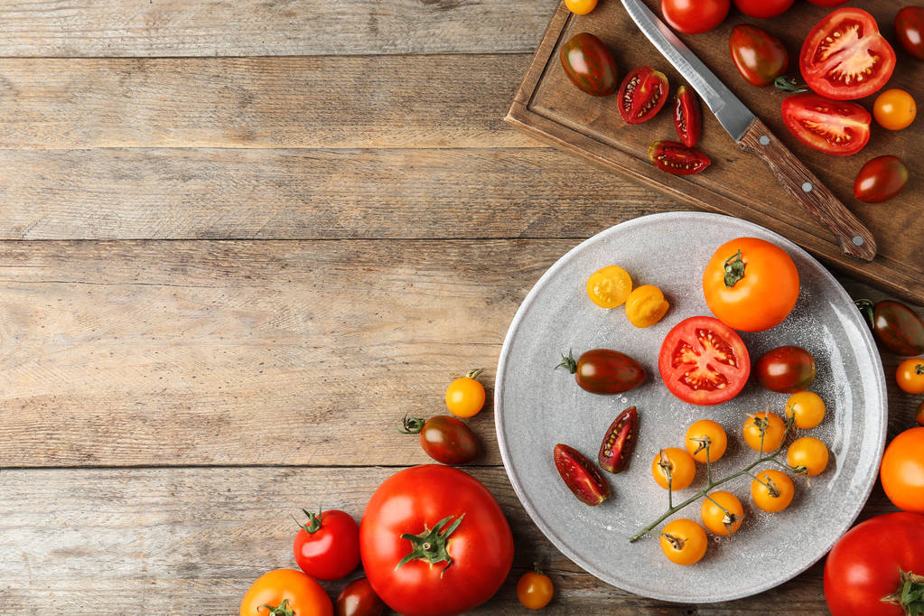 Poser à plat la composition avec des tomates fraîches mûres sur une table en bois. Espace pour le texte
 - Photo, image