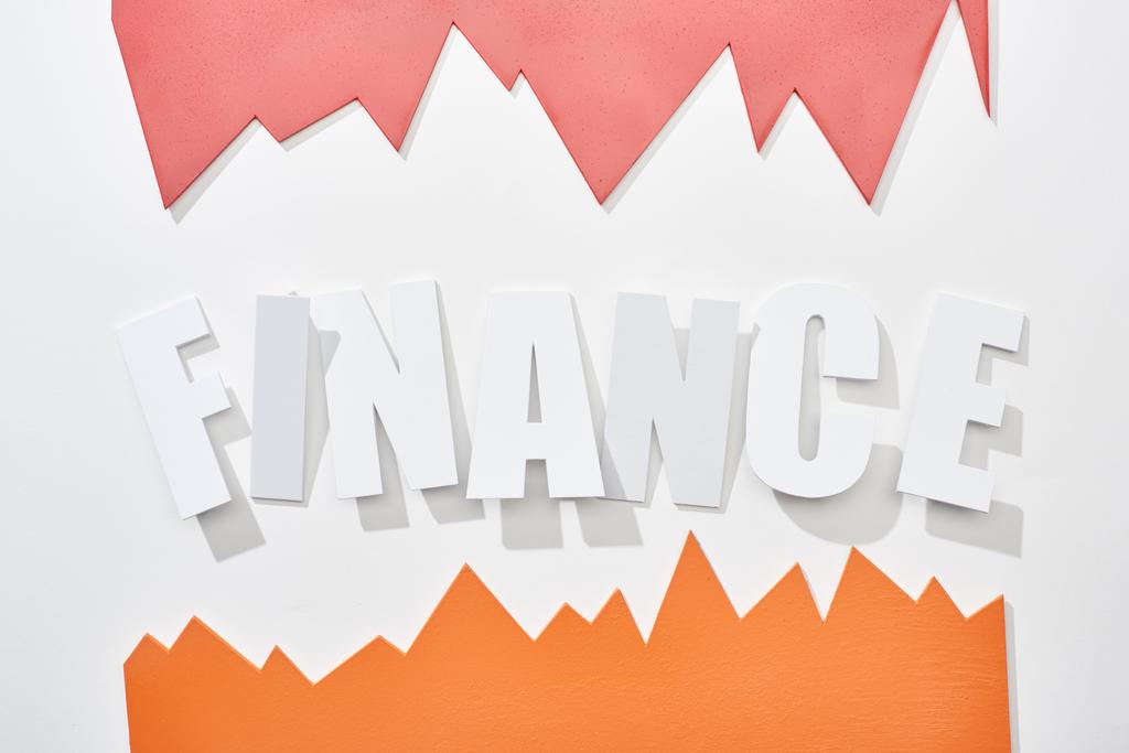 Draufsicht der Finanzinschrift mit orangefarbenen und rosafarbenen Statistikgraphen auf weißem Hintergrund - Foto, Bild