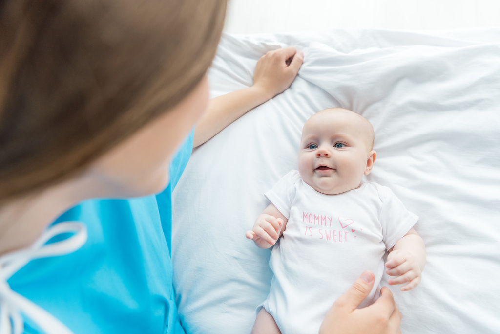 vista de ángulo alto de lindo bebé mirando a la madre en el hospital
  - Foto, Imagen