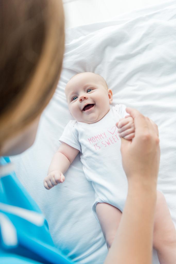 επιλεκτική εστίαση του χαριτωμένο μωρό κοιτάζοντας τη μητέρα στο νοσοκομείο  - Φωτογραφία, εικόνα