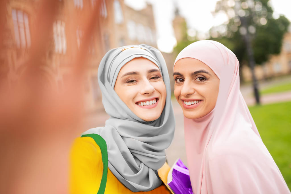 Kobiety muzułmańskich studentów ubrany hijabs uśmiechając się szeroko - Zdjęcie, obraz