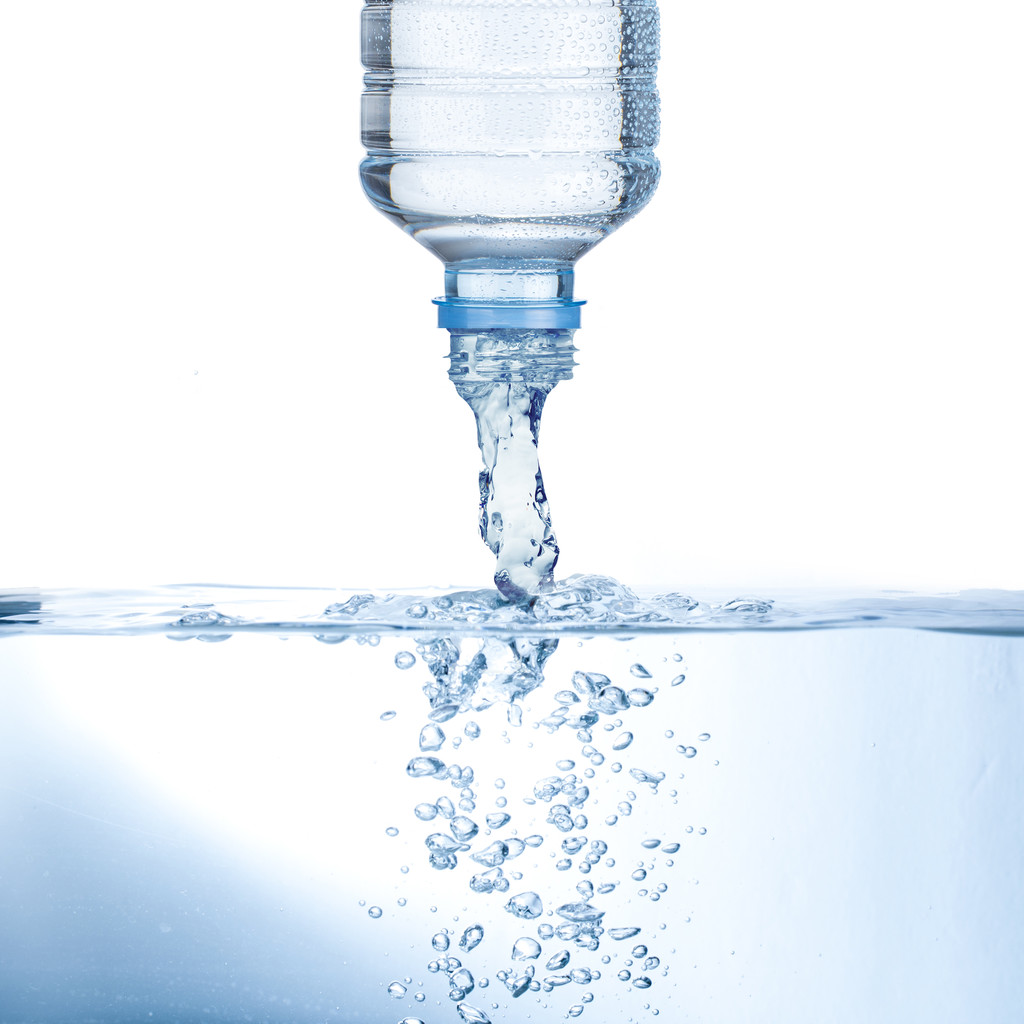 Вода наливається з пляшки води
 - Фото, зображення