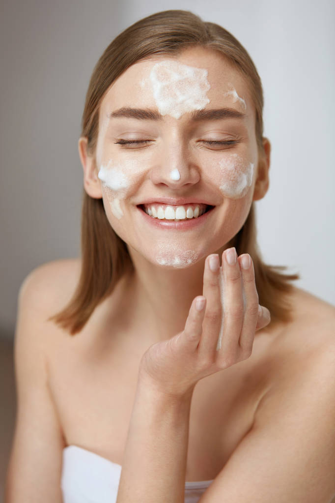 Kasvojen ihonhoito. Nainen puhdistaa kasvojen ihon vaahto saippualla
 - Valokuva, kuva