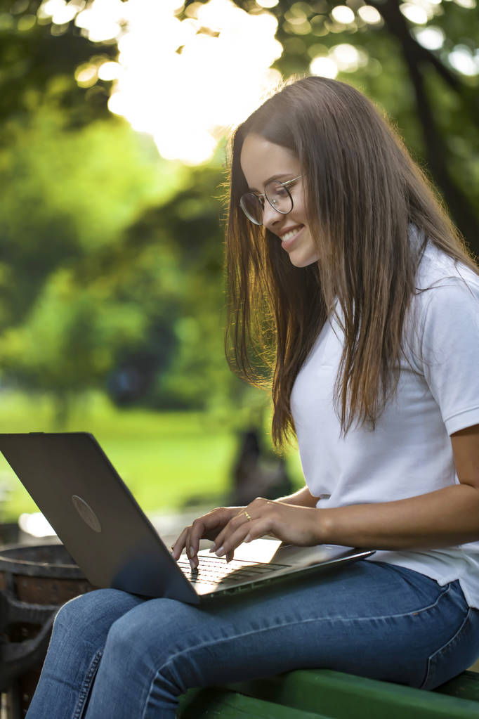 Aranyos diák lány használata laptop a parkban - Fotó, kép