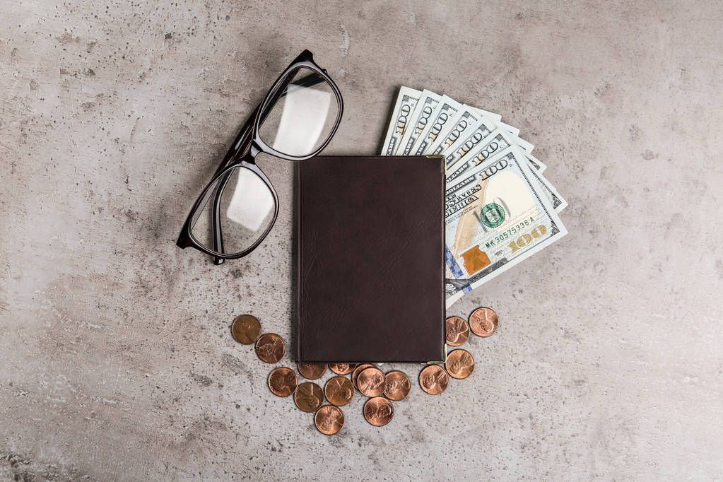 Rentenbescheinigung mit amerikanischem Geld und Brille auf grauem Steintisch, flach gelegt - Foto, Bild
