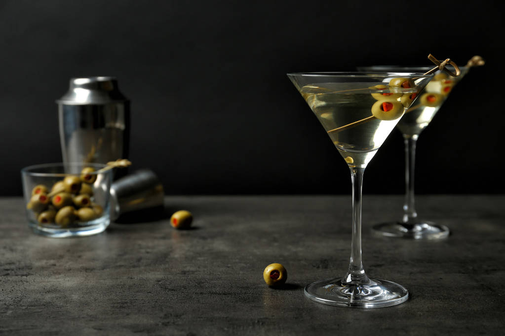 Szemüveg Classic Dry Martini az olajbogyó a szürke tábla fekete háttér előtt - Fotó, kép