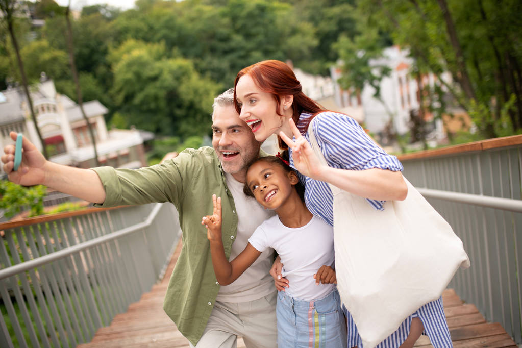 Famiglia allegra fare selfie mentre si cammina in città
 - Foto, immagini