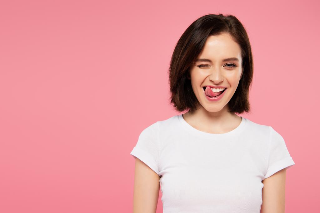 beautiful girl showing tongue and winking isolated on pink - Photo, Image