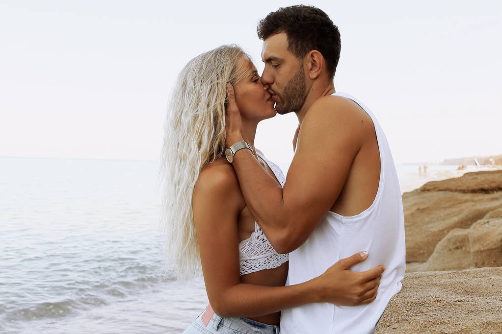 ジーンズを着て美しいカップル、夏のビーチでポーズ - 写真・画像