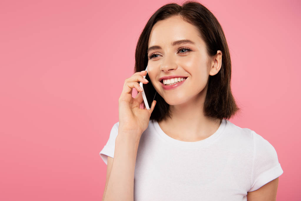 beautiful smiling girl talking on smartphone isolated on pink - Photo, Image