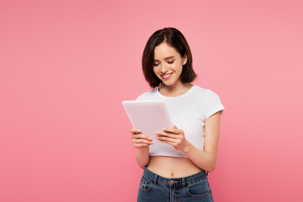 krásná usměvavá dívka používající digitální tablety izolované na růžovém - Fotografie, Obrázek