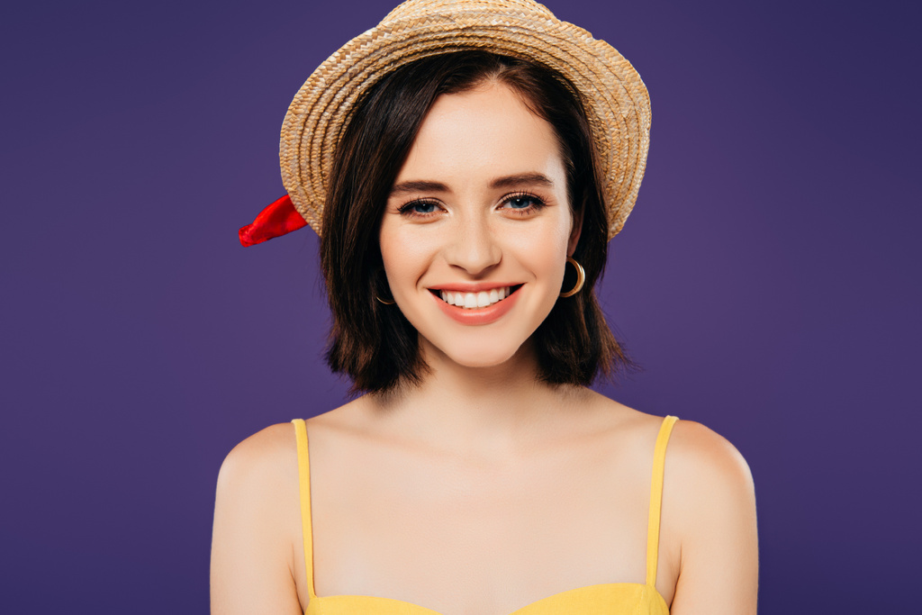 Gelukkig glimlachend meisje in stro hoed geïsoleerd op paars - Foto, afbeelding