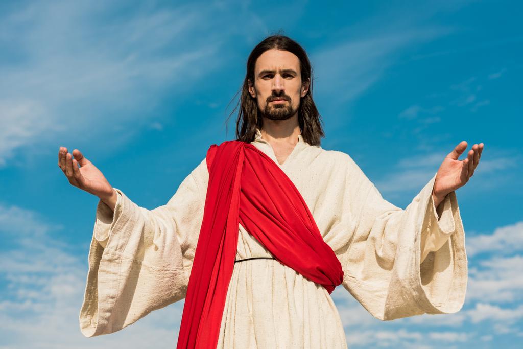 Gesù barbuto con le mani tese contro il cielo blu
  - Foto, immagini
