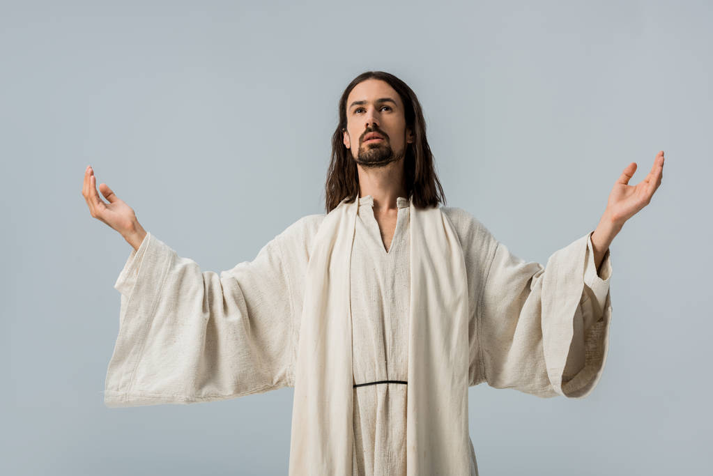 knappe man in Jezus gewaad met uitgestrekte handen geïsoleerd op grijs - Foto, afbeelding