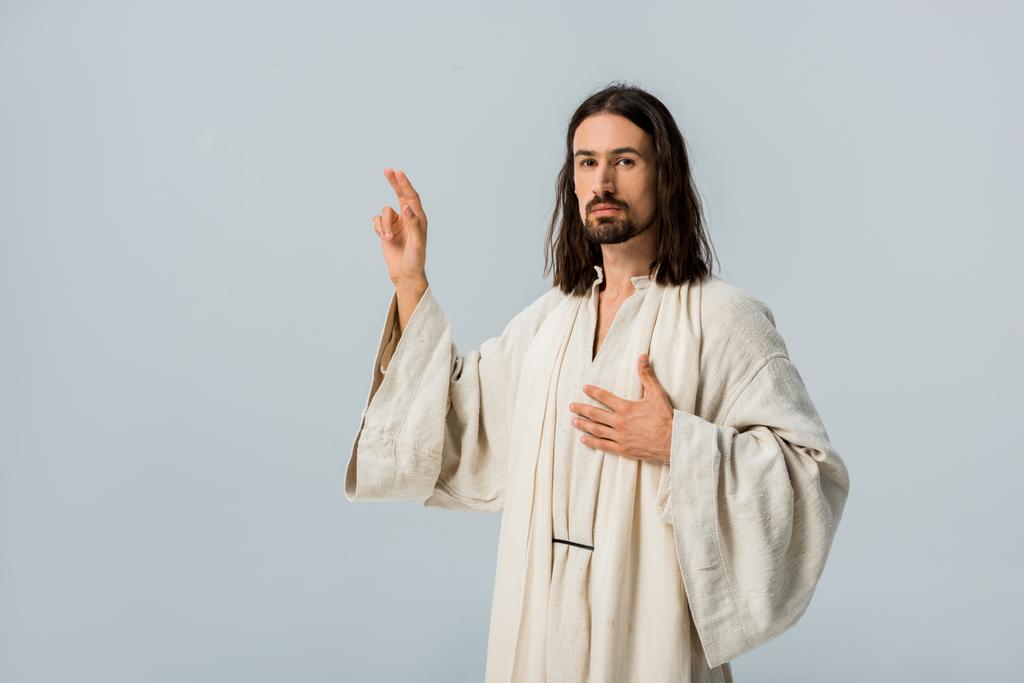 bärtiger Mann betet mit der Hand auf der Brust isoliert auf grau  - Foto, Bild