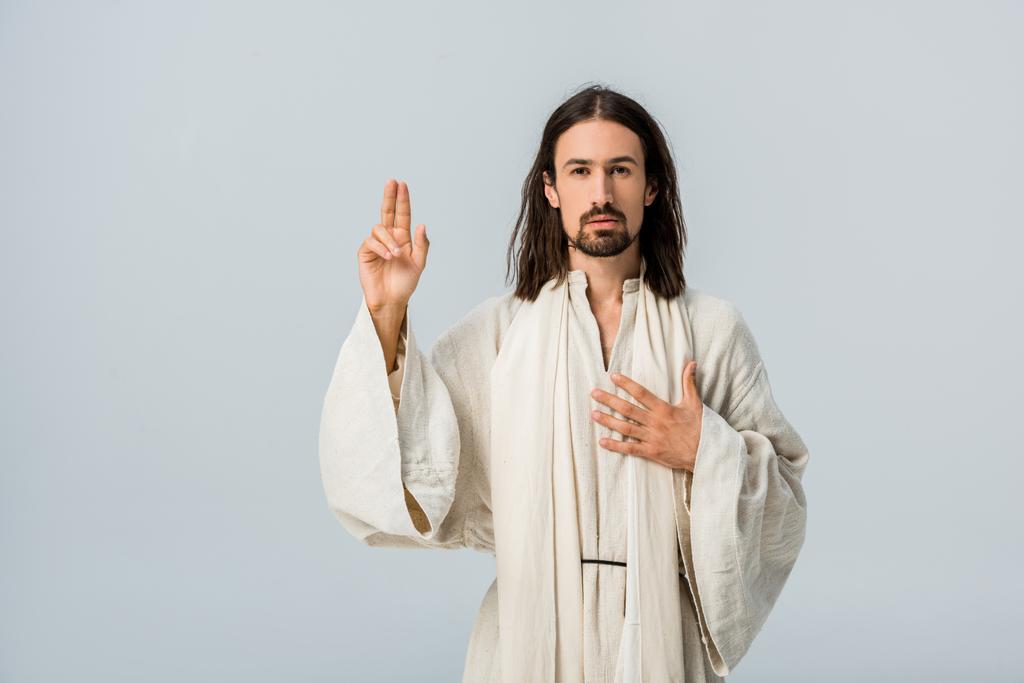 vousatý muž, který se modlí rukou na prsa izolovaná na šedé  - Fotografie, Obrázek