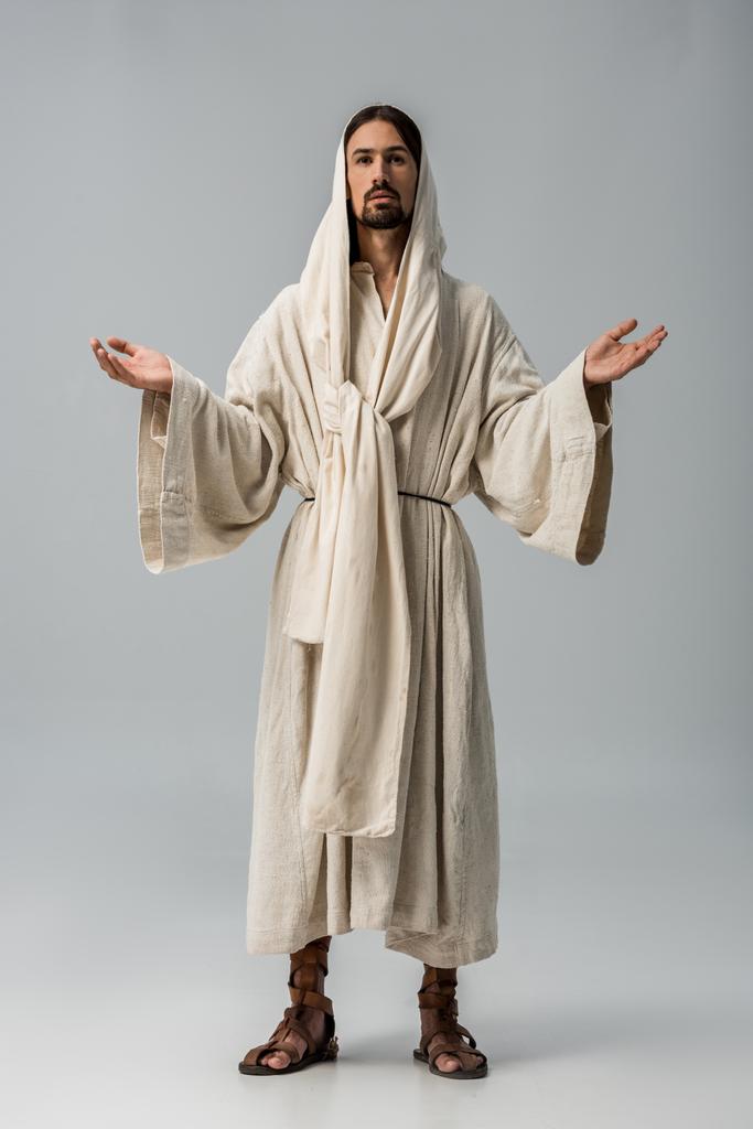 homme barbu à capuche debout avec les mains tendues isolé sur gris
  - Photo, image