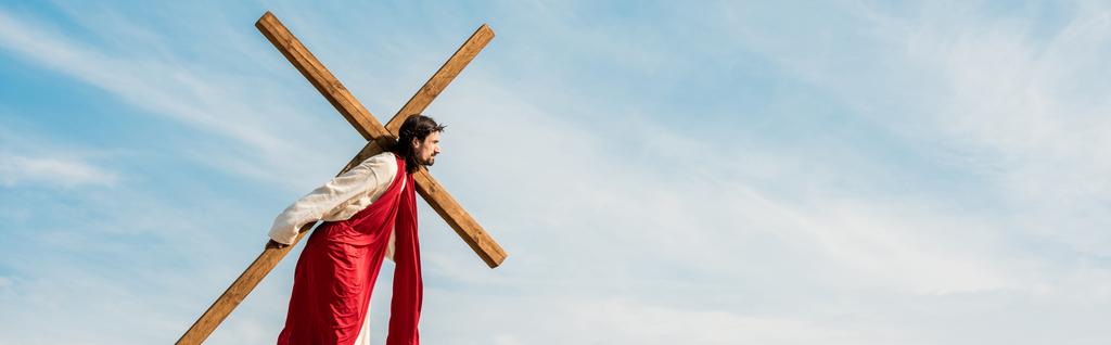 plano panorámico del hombre barbudo caminando con cruz de madera
  - Foto, imagen