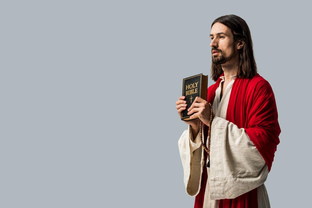 hombre barbudo guapo sosteniendo la Biblia santa aislado en gris
  - Foto, Imagen