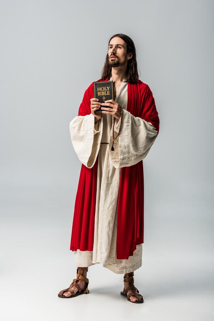 bonito religioso homem segurando sagrada bíblia no cinza
  - Foto, Imagem