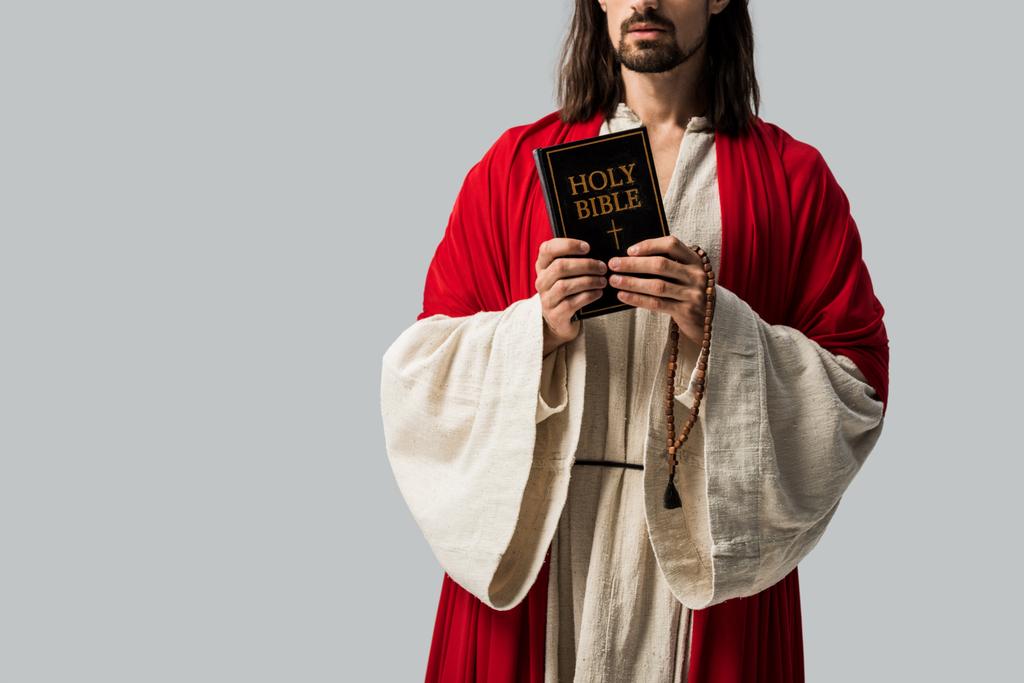 oříznutý pohled náboženského muže v Ježíšově róbě s posvátná Bible izolovaná na šedé - Fotografie, Obrázek