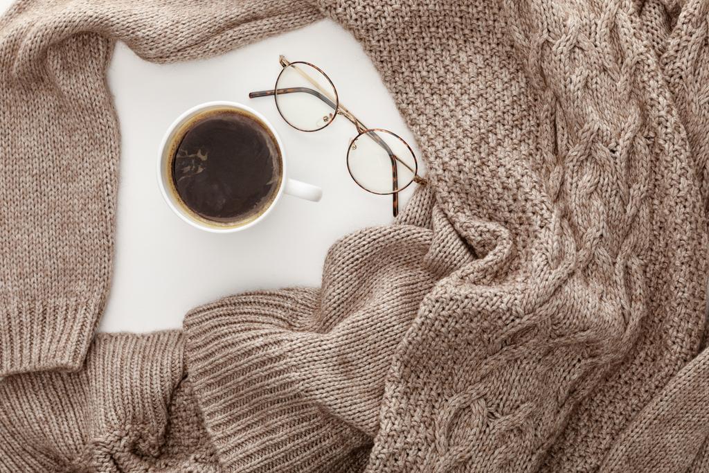 vista superior del suéter marrón de punto, café y vasos sobre fondo blanco
 - Foto, imagen