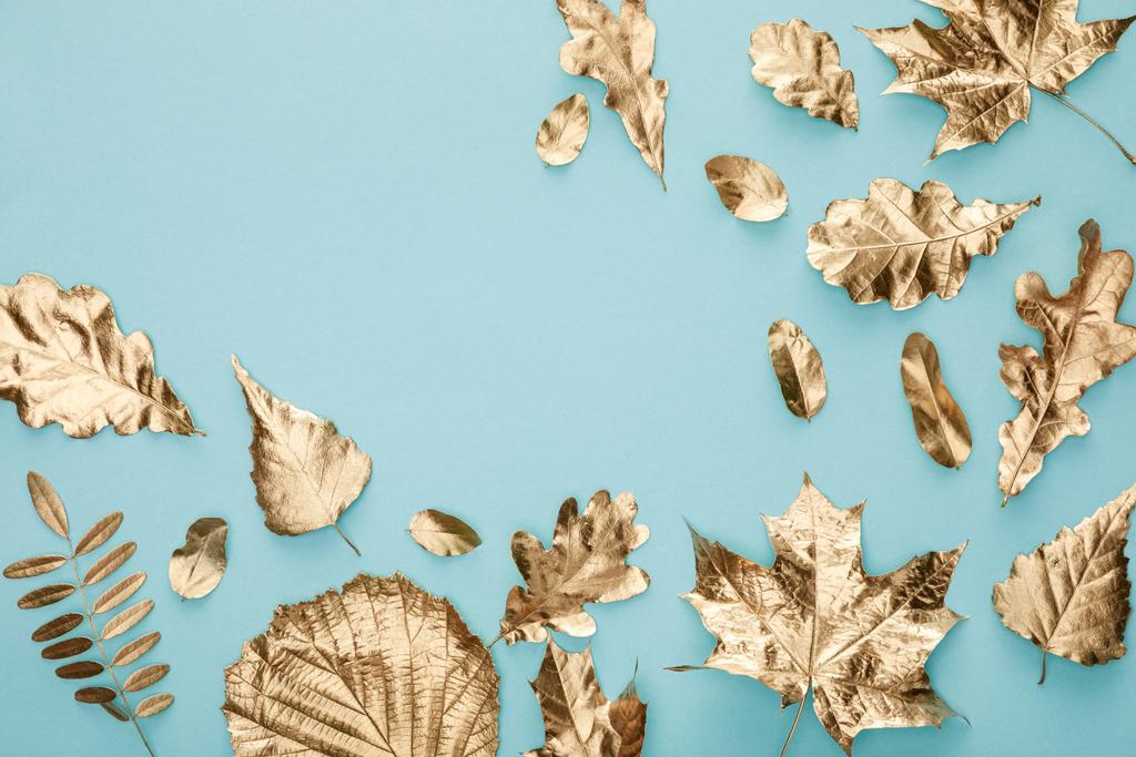 top view of autumnal golden leaves on blue background with copy space - Photo, Image