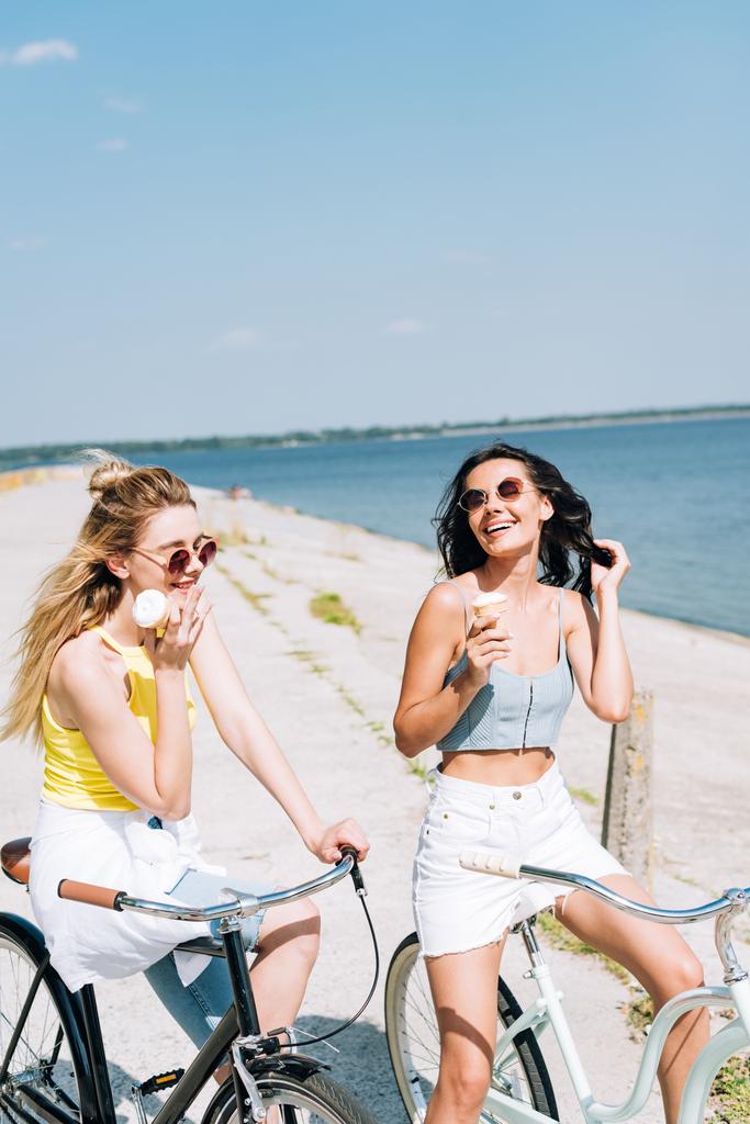 filles heureuses à vélo avec crème glacée près de la rivière en été
 - Photo, image