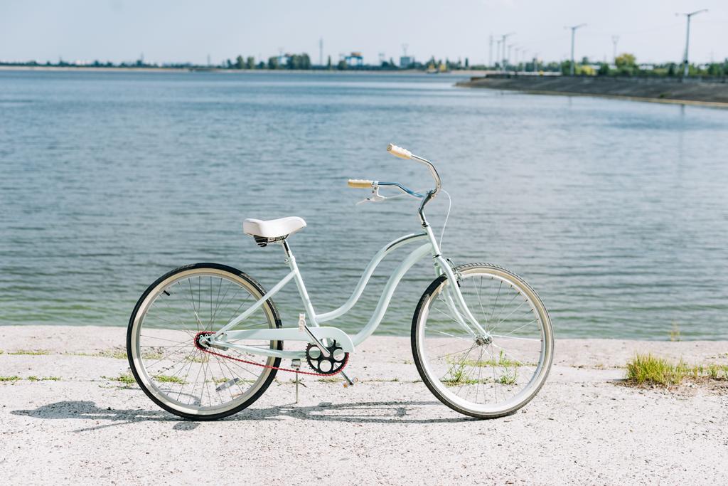 vista lateral de la bicicleta cerca del río azul en verano bajo el sol
 - Foto, imagen