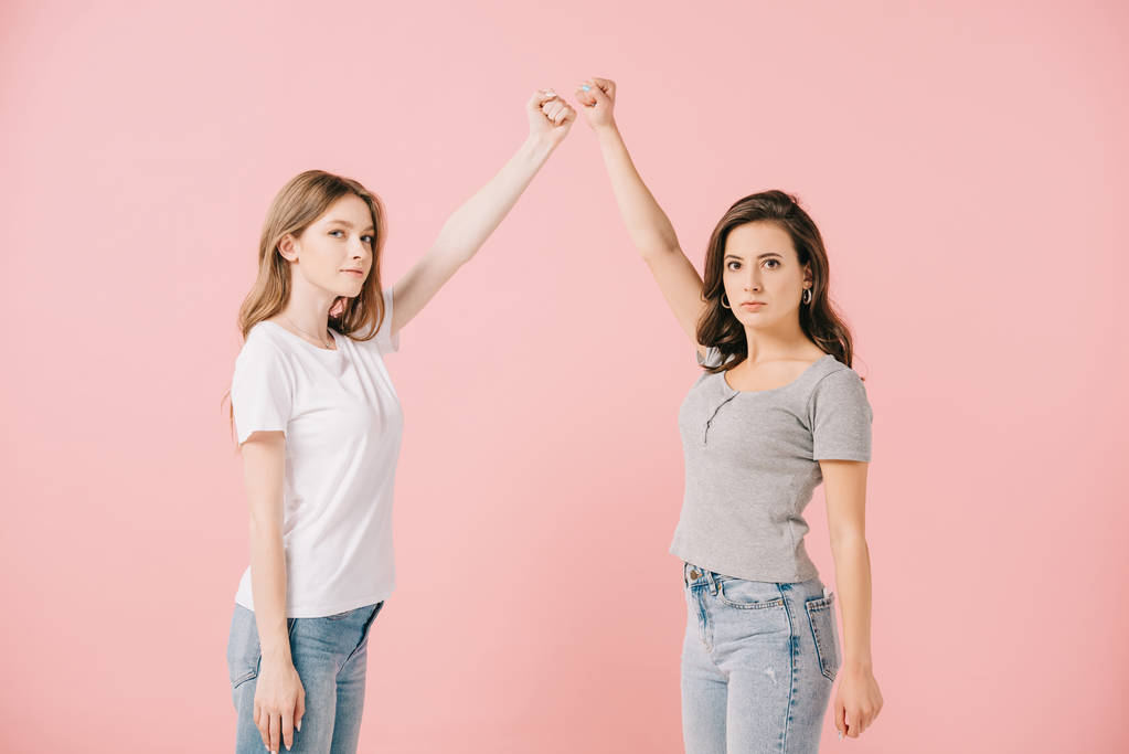 mujeres atractivas en camisetas mostrando puños y mirando a la cámara aislada en rosa
 - Foto, Imagen