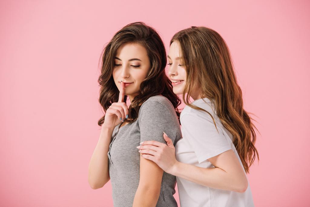 mujeres atractivas en camisetas que muestran gesto shh aislado en rosa
 - Foto, imagen