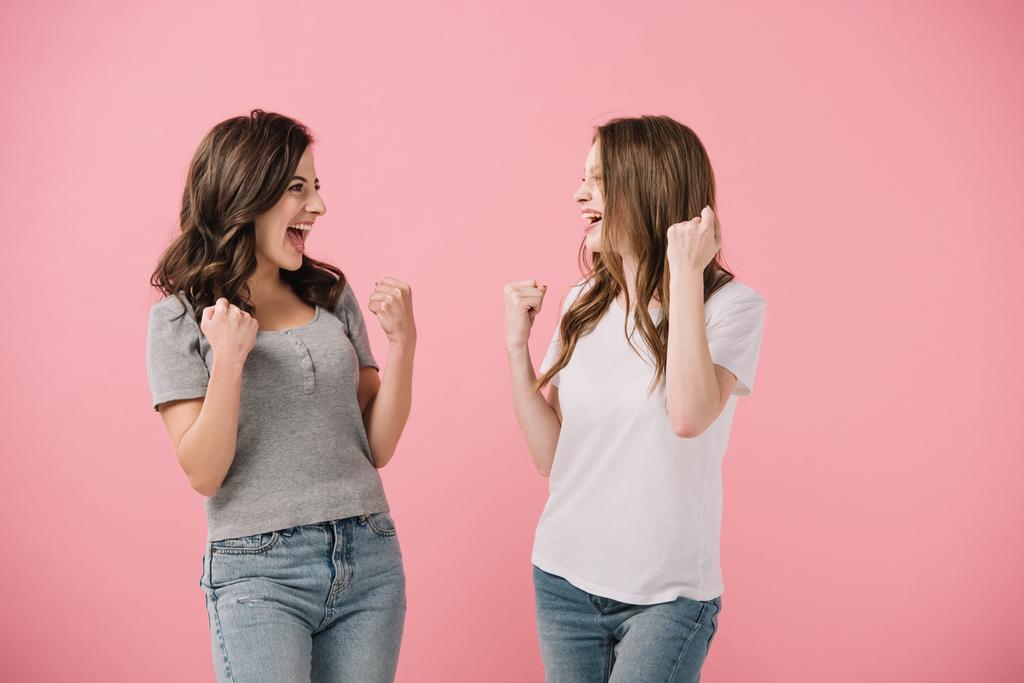 aantrekkelijke en lachende vrouwen in t-shirts tonen ja gebaren geïsoleerd op roze - Foto, afbeelding