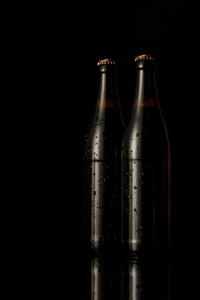glass bottles of beer with drops isolated on black - Photo, Image