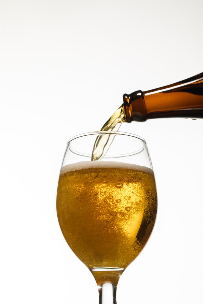 low angle view of fresh beer pouring from bottle into glass isolated on white - Photo, Image