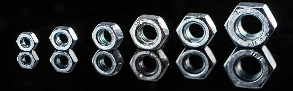 Panoramaaufnahme von glänzenden neuen Metallmuttern isoliert auf Schwarz - Foto, Bild