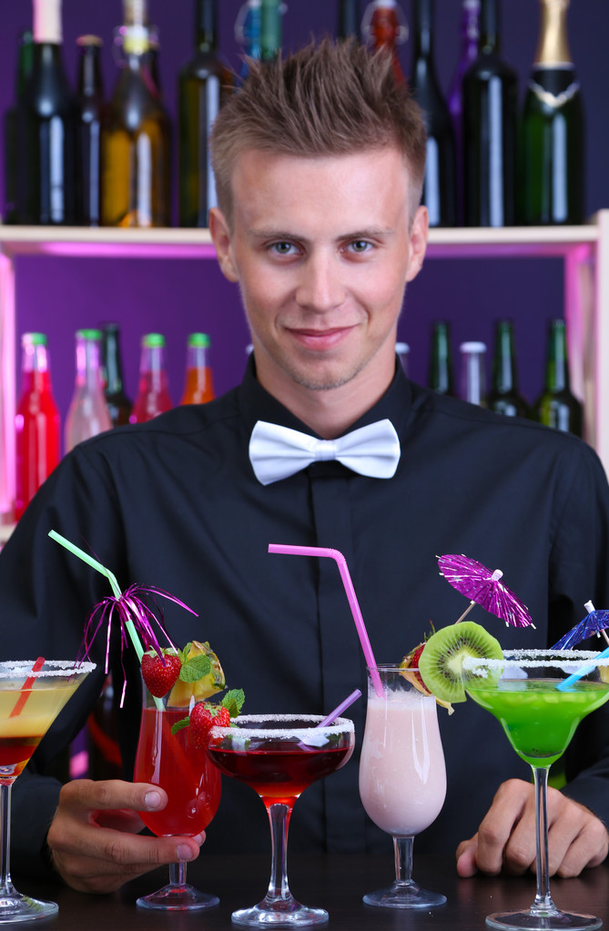 Retrato de barman guapo con cócteles diferentes, en el bar
 - Foto, Imagen
