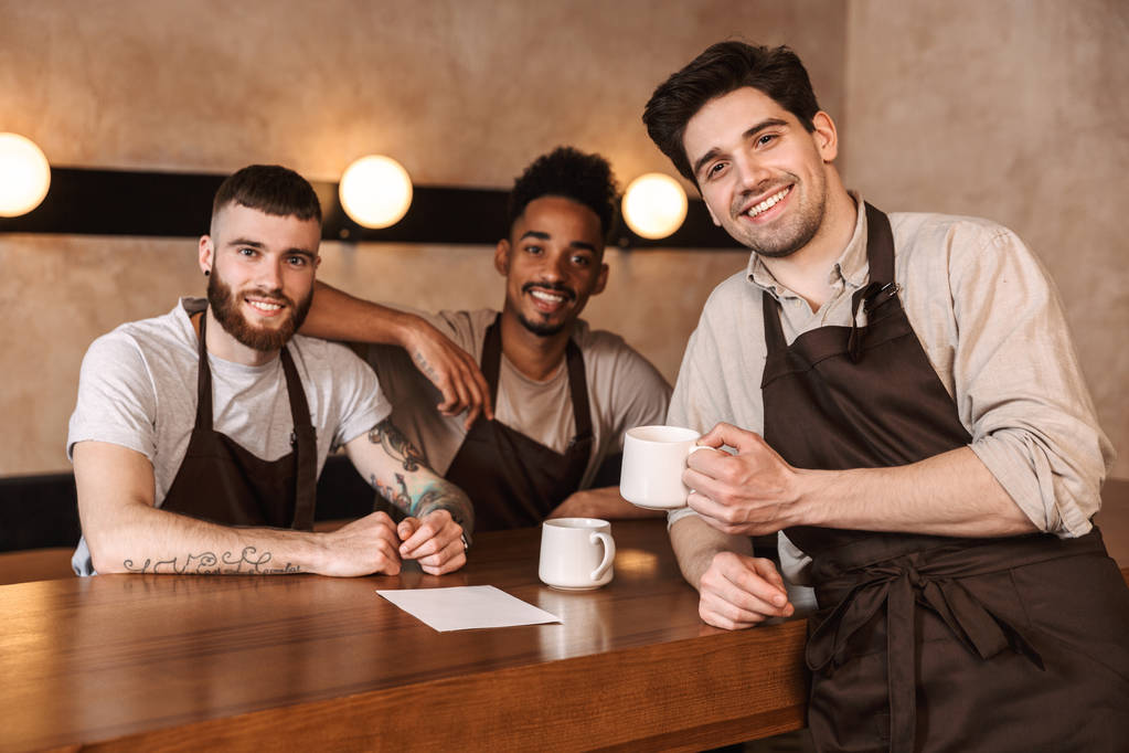 Três baristas homens alegres no café
 - Foto, Imagem