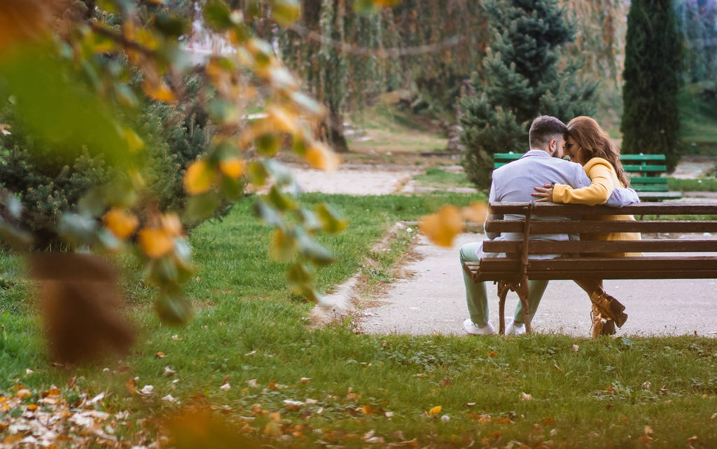 Εξωτερική φωτογραφία, όμορφο, νεαρό ζευγάρι, κάθεται σε ένα παγκάκι στο πάρκο. - Φωτογραφία, εικόνα