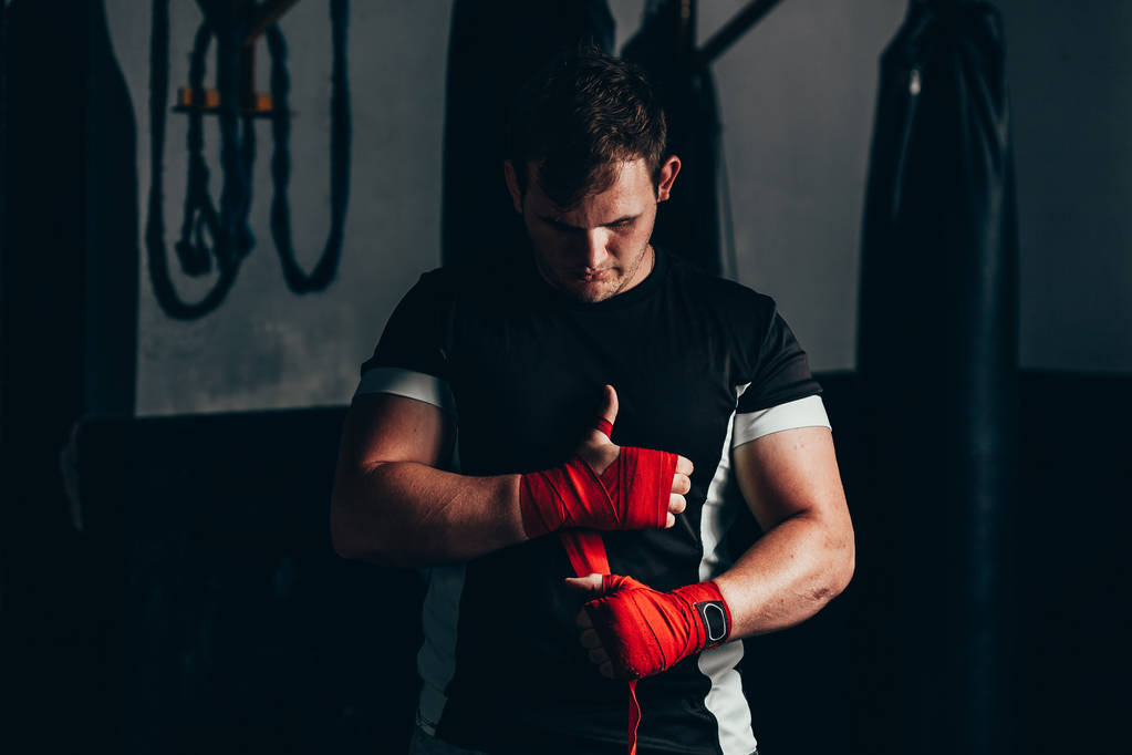 Starker Boxer zieht rote Riemen an und macht sich bereit zum Kampf - Foto, Bild