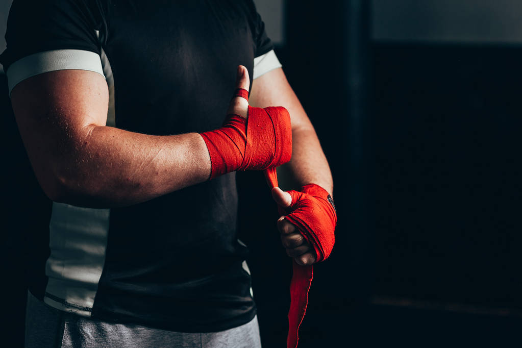 Sterke Boxer Putting op rode riemen en het krijgen van klaar om te vechten - Foto, afbeelding