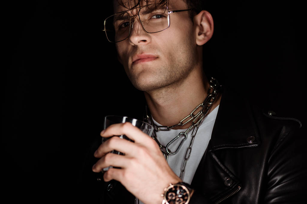 selectieve focus van stijlvolle man in oog glazen met whiskey geïsoleerd op zwart  - Foto, afbeelding