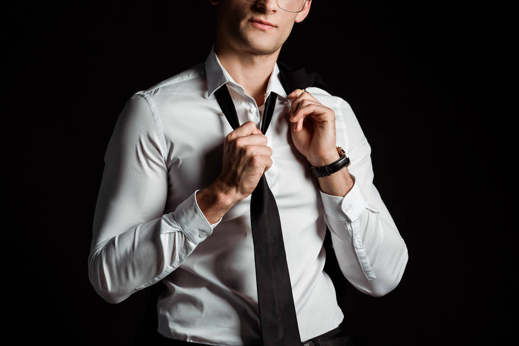 Ausgeschnittene Ansicht eines Geschäftsmannes, der Krawatte auf Schwarz auszieht  - Foto, Bild
