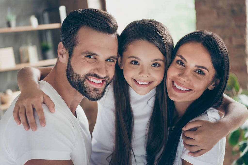Close-up portrait of nice attractive lovely adorable affectionate gentle careful cheerful cheery family wearing casual white t-shirts cuddling at industrial loft style interior room house - Fotografie, Obrázek