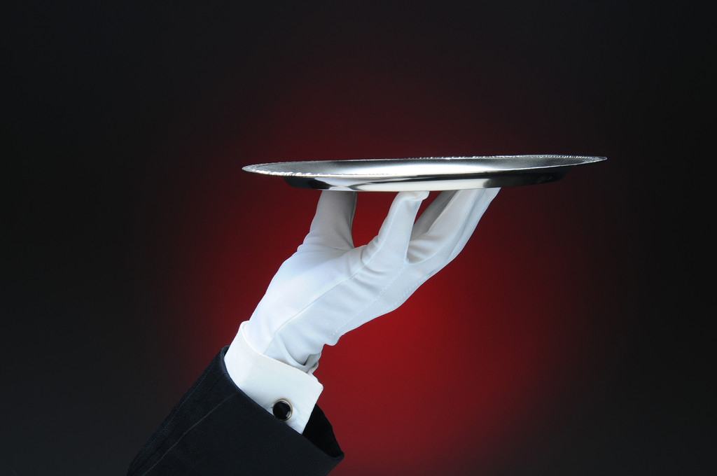 Официант держит серебряный поднос для еды в кончиках пальцев
 - Фото, изображение