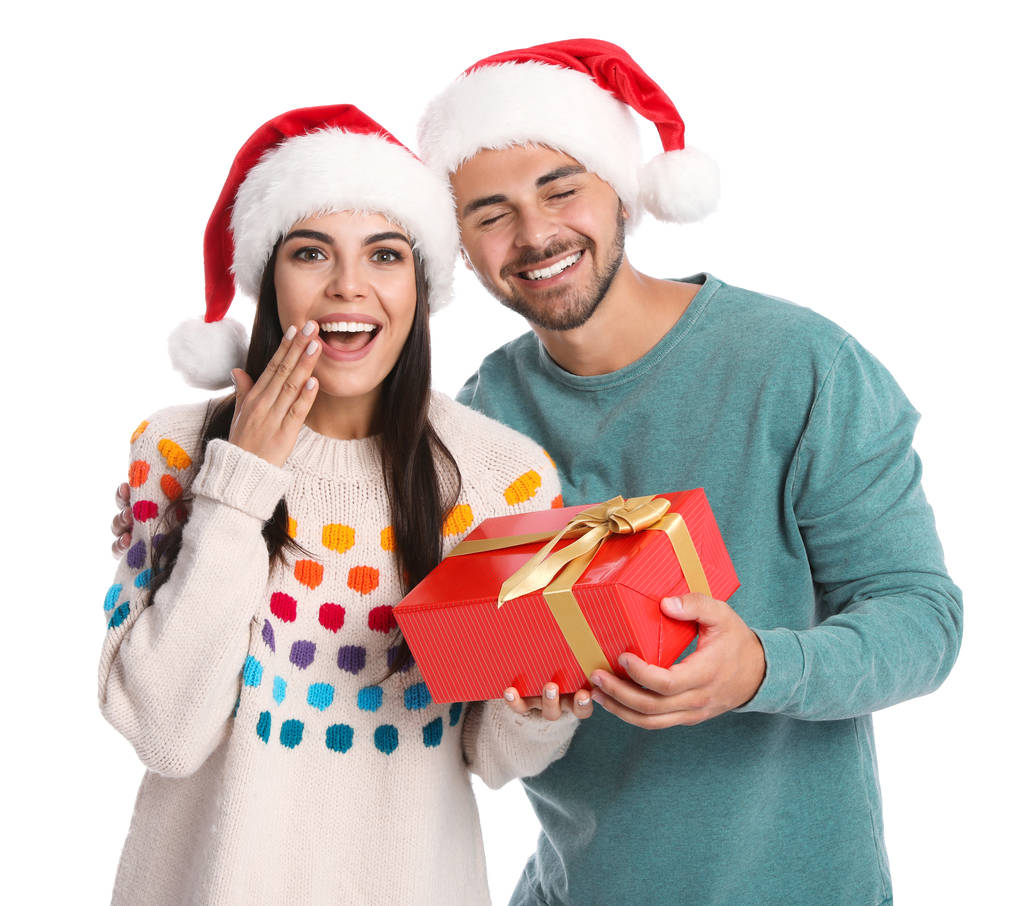 Young man giving gift box to his girlfriend on white background. Christmas celebration - Photo, Image