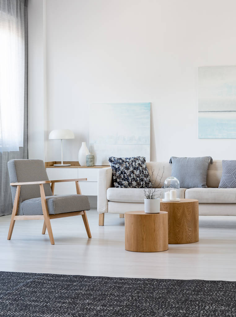 Duas mesas de café de madeira com planta no potenciômetro na frente do sofá cinzento da esquina no interior elegante da sala de estar
 - Foto, Imagem