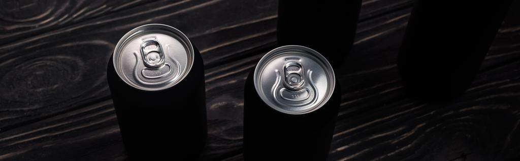 ahşap masa üzerinde bira siyah alüminyum kutu panoramik çekim  - Fotoğraf, Görsel
