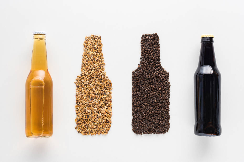 вид зверху пляшки темного і світлого пива біля пшениці і зерна кави ізольовані на білому
 - Фото, зображення