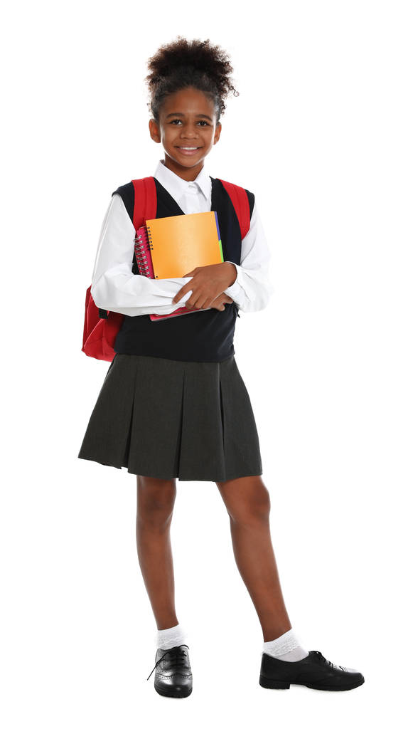 Ευτυχισμένο αφροαμερικάνικο κορίτσι με τη σχολική στολή σε λευκό φόντο - Φωτογραφία, εικόνα