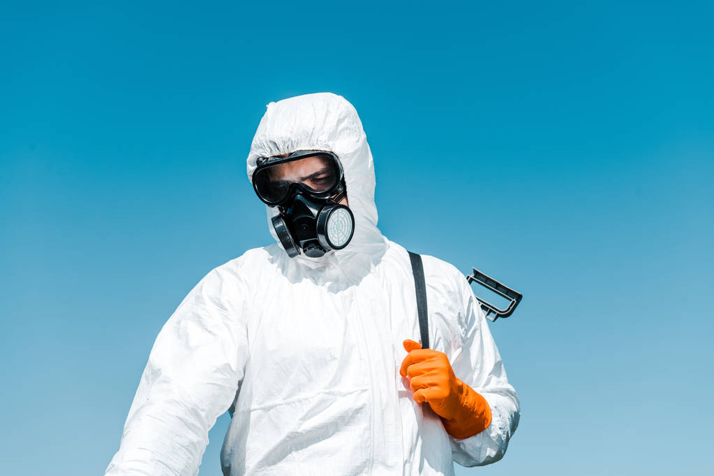 exterminador em uniforme branco e luva de látex segurando spray
  - Foto, Imagem